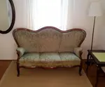 Wohnzimmer mit ovalem Spiegel und antikem Dreisitzer-Sofa