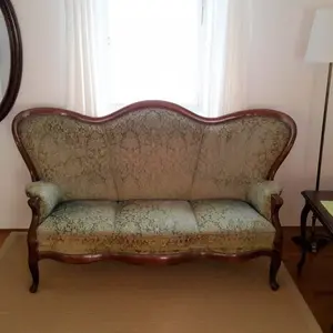 Wohnzimmer mit ovalem Spiegel und antikem Dreisitzer-Sofa