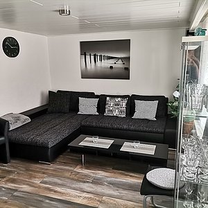 Gästehaus Isabelle Wohnzimmer mit moderner Einrichtung in schwarz-weiß gehalten 