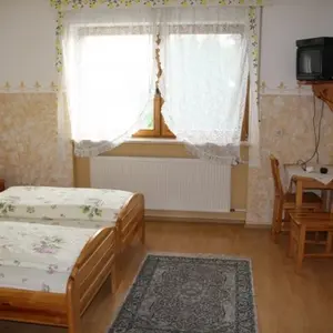Gemütliches udn helles Schlafzimmer mit Doppelbett aus Kiefernholz