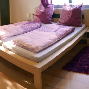 Schlafzimmer mit Doppelbett und Holzfußboden