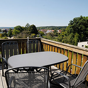 Gartenmöbel auf Balkon mit schöner Aussicht ins Grüne